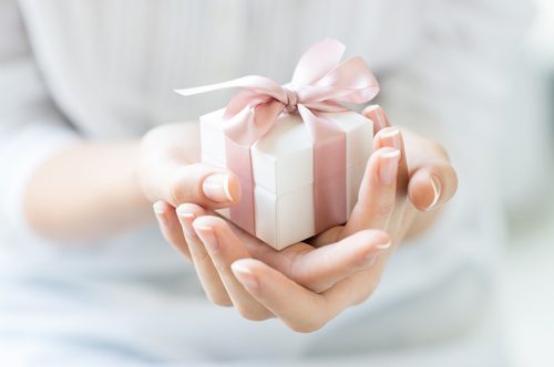 woman holding small wrapped gift