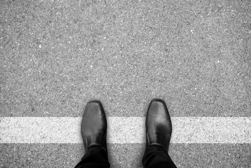feet on white line in parking lot or street