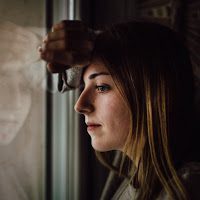 sad woman looking out window