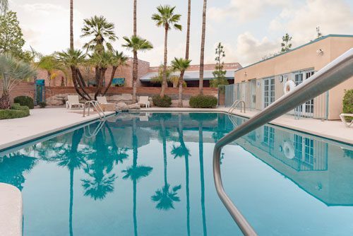 beautiful outdoor pool surrounded by palm trees - Cottonwood Tucson holistic rehab in Arizona